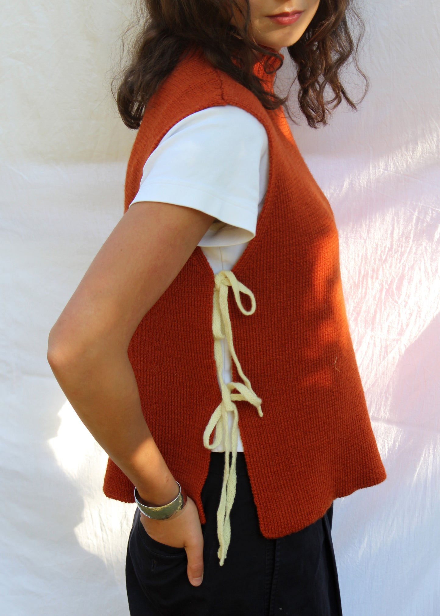 Model in orange wool vest with yellow ties.