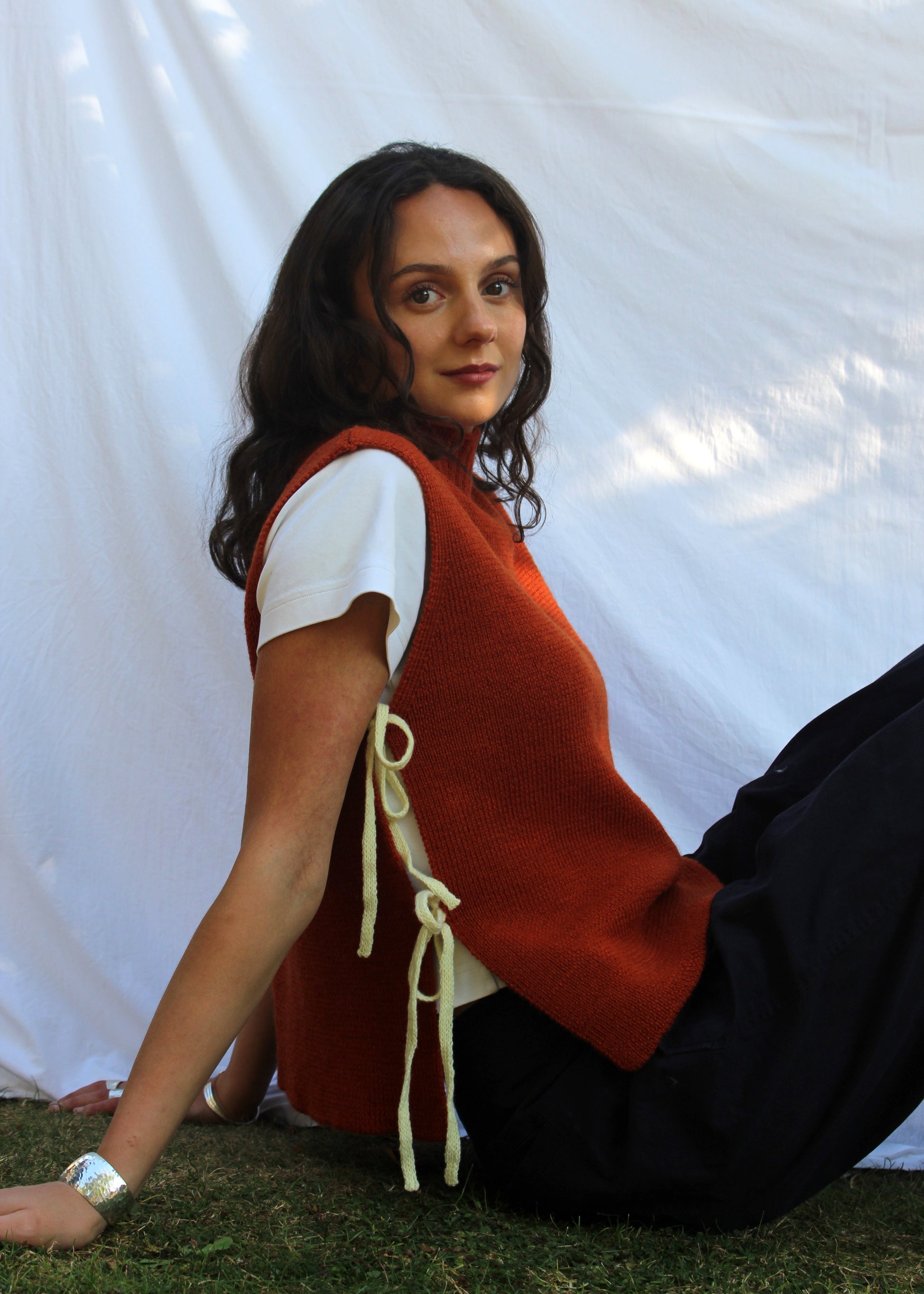 Model in orange wool vest with yellow ties. 